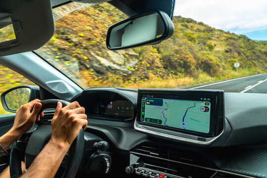 Person driving car on road navigating with gps during vacation