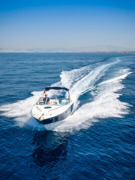 Aerial front view of a motorboat cruising with high speed over calm ocean