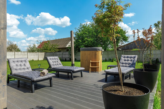 Sunny Backyard Spa Deck with Sun Loungers and Hot Tub