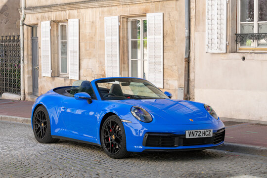 Nancy, France - June 13th 2026 : View on a blue Porsche 992 Carrera 4S Cabriolet parked on a street. The Porsche 992 is the eighth generation of the Porsche 911 sports car. This is the 992.1 version.