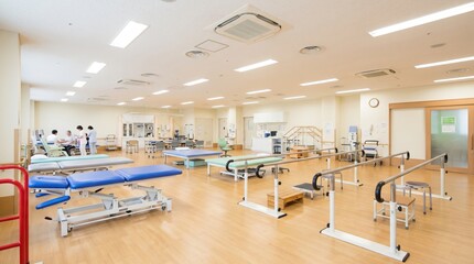 Fototapeta premium Spacious physical therapy room inside a modern medical rehabilitation center equipped with treatment beds, parallel bars, and exercise equipment for patient recovery and health care services