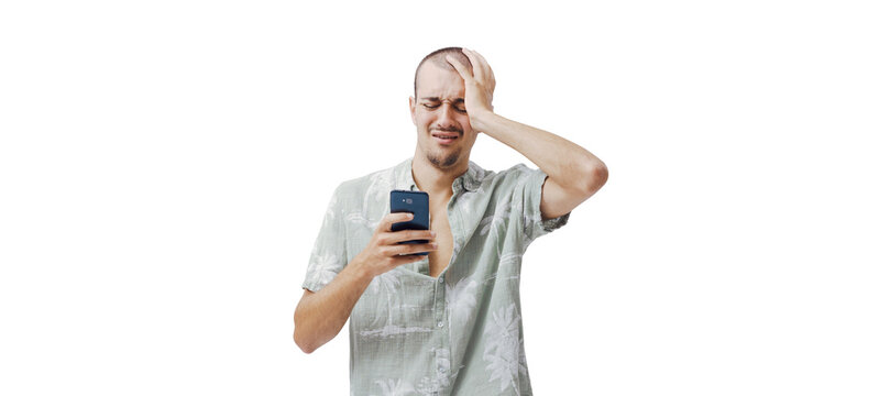 Stressed Young Man with Hand on Head Looking at Smartphone on Pink Background