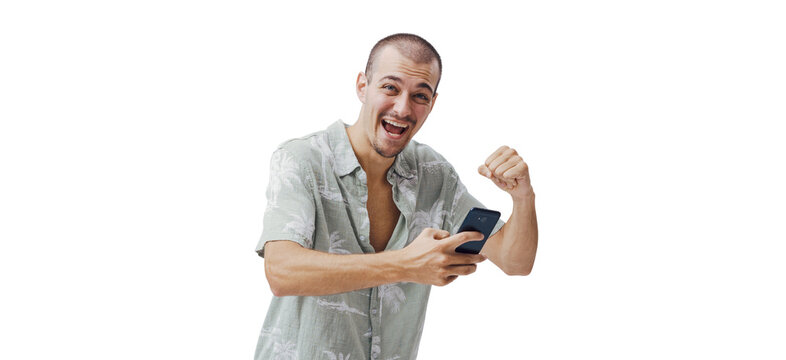 Ecstatic Young Man Celebrating with Smartphone and Raised Fist on Green Background