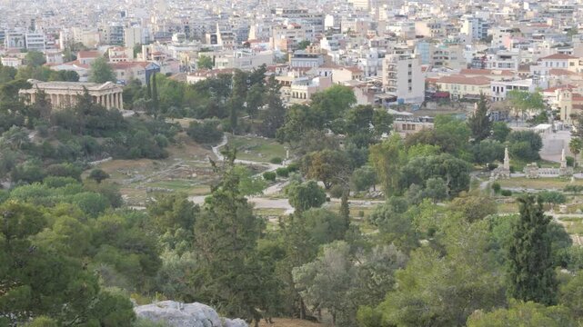 Panoramic perspective showcasing the Ancient Agora's ruins amidst the bustling cityscape of Athens, Greece.