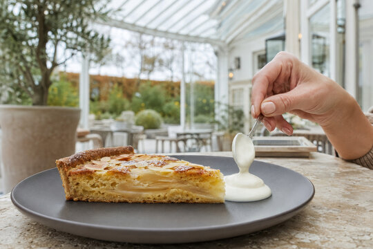 Postre con tarta de manzana y crema en un caf&eacute; con terraza en un d&iacute;a tranquilo
