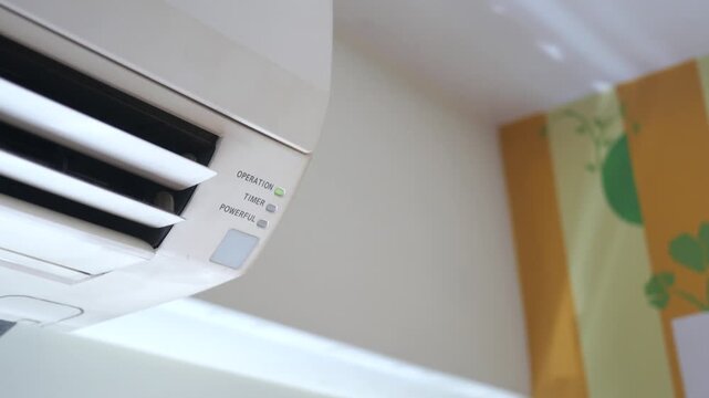Close up of air conditioner operation light blinking on and louvers moving gently