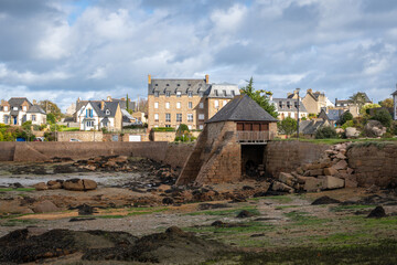 Historic tidal mill surrounded by granite houses in Tregastel, Brittany, France © daboost