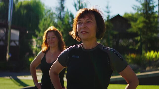 Elderly women practicing slow motion Pilates exercises outdoors, focusing on gentle stretching, balance, and mindful movement for healthy aging and active lifestyle
