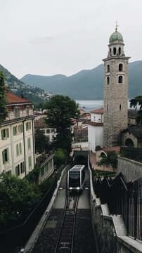 Lugano postcard view with tram and historic Cathedral of San Lorenzo in front of Lago di Lugano in the background, Ticino, Switzerland