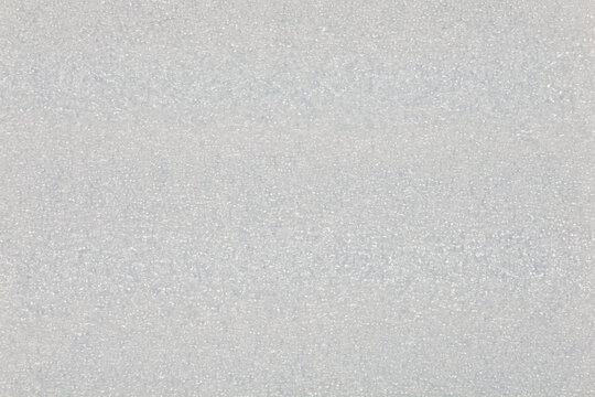 A close up full frame background texture of a white expanded polyethylene foam sheet used for packaging protection and cushioning.
