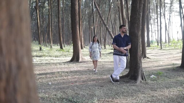 Romantic Couple Walking Together in a Serene Pine Forest During Daylight