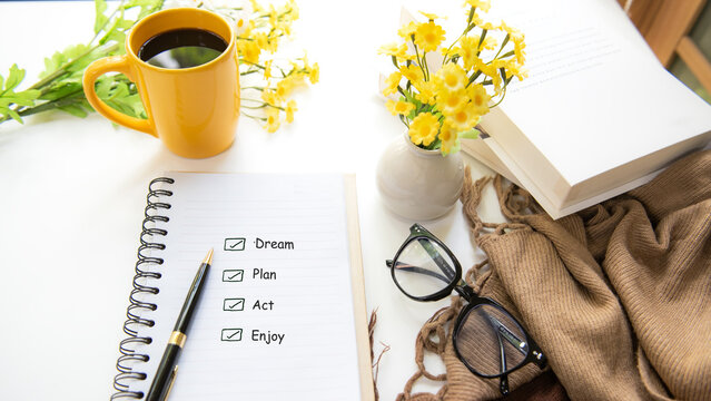 Notebook with life goals checklist on bright workspace for personal growth and future planning with yellow cup coffee in warm sunshine.  Goal Life Wellness Concept.