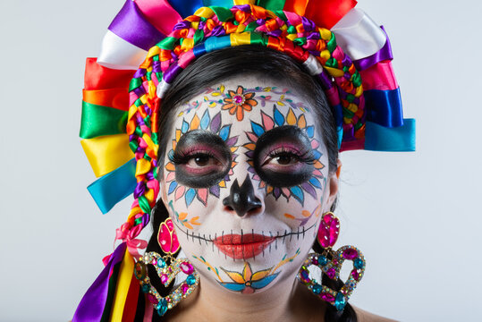 Close Up Portrait of Woman with Colorful Catrina Makeup for Day of the Dead on Gray Background