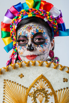 Woman with Colorful Catrina Makeup Holding Traditional Mexican Charro Sombrero on White Background