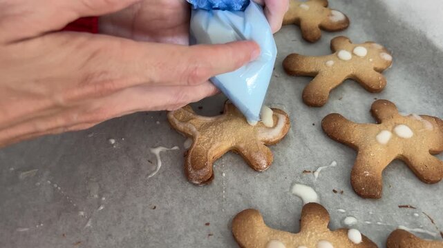 Manos decorando galletas navide&ntilde;as con glaseado