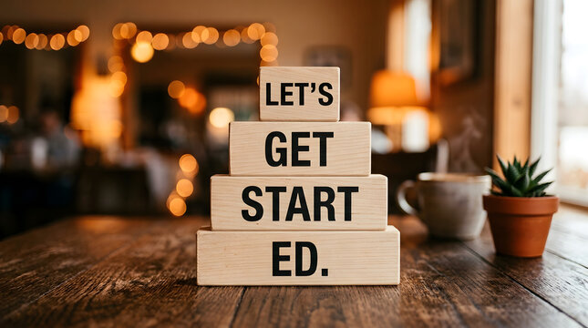 Wooden blocks with the text let's get started on a table in a cozy cafe