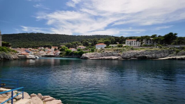 Colorful traditional houses and recreational boats line serene harbor in Mali Losinj, Croatia, capturing the essence of idyllic Adriatic travel destination on Losinj Island in Croatia