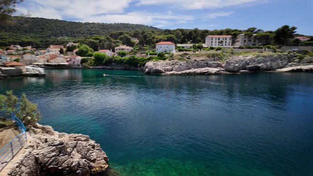 Mali Losinj harbor on Losinj Island. Croatia. Offering a scenic coastal view with traditional buildings. A prominent church steeple of Losinj Island in Croatia