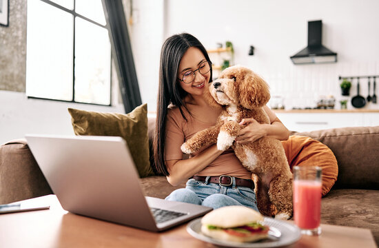 oman working from home with her dog on the couch.