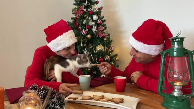 Pareja con gato disfrutando galletas de Navidad
