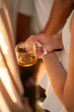 Cropped view of a woman holding a transparent glass mug of warm tea indoors