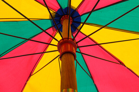 Low-angle view of a colorful beach umbrella canopy with vibrant geometric panels