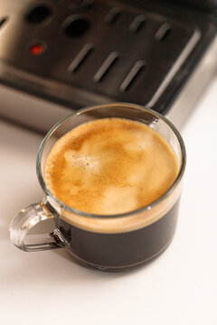 Close-up of freshly brewed black coffee served in a clear glass cup with rich crema, A warm and cozy beverage concept for caf&eacute;s, breakfast, and everyday lifestyle