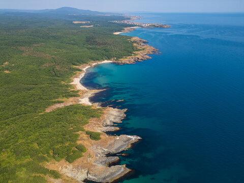 Aerial Top-Down View of Rocky Coastline and Deep Blue Sea Water