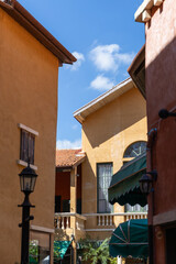 Obraz premium Narrow alleyway between Italian style yellow buildings under a blue sky