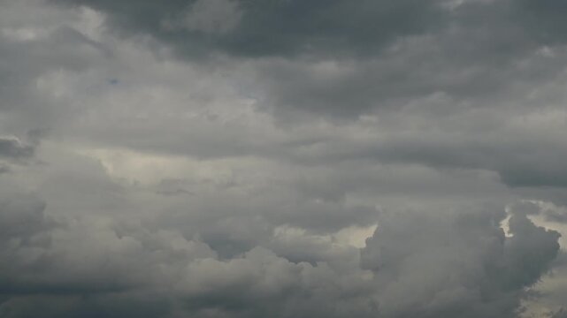 time lapse of gathering dense clouds above haze layer and light horizon on stormy day