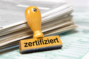 Ein Holzstempel mit Aufdruck zertifiziert über Dokumenten