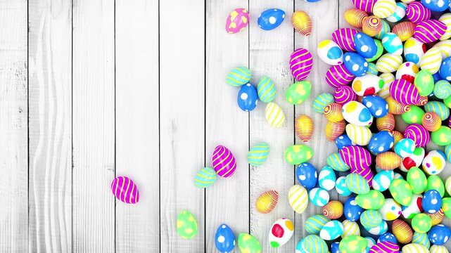 Colorful decorated Easter eggs tumble and scatter from the right across a whitewashed wooden plank background, creating a festive spring holiday border, 3d animation