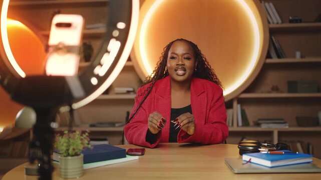 Stylish African woman personal growth coach recording a video on phone for blog