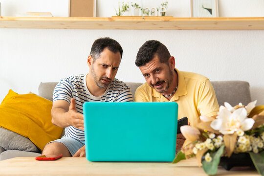 Men discussing difficult problem together using laptop