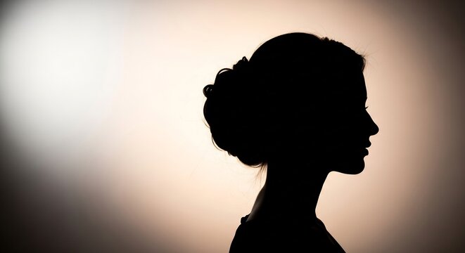 Side profile silhouette of a woman with an elegant updo hairstyle.