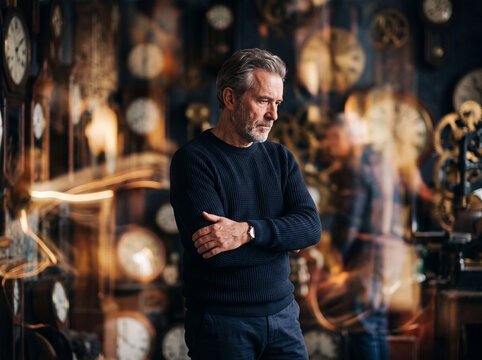 Male menopause and andropause theme with thoughtful mature man standing in front of clock background