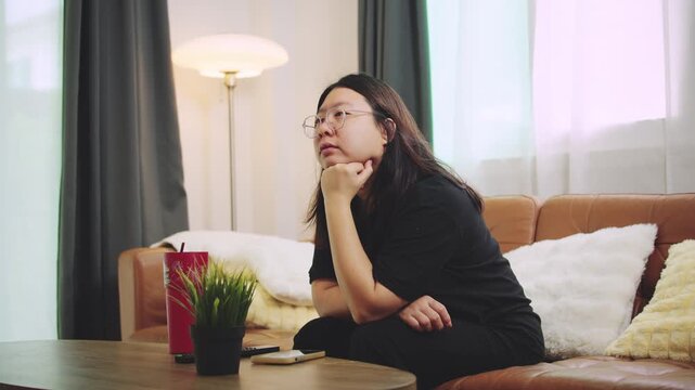 young woman sitting on sofa and drinking coffee watching television. hobbies ceoncept.