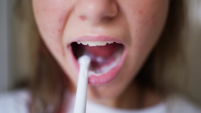 Teenage girl maintaining good oral hygiene by brushing her teeth during a relaxing morning routine at home. Healthy habits, dental health and personal wellness.