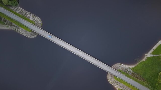 Epic top-down drone view of car crossing Blessington Lakes bridge, County Wicklow, Ireland
