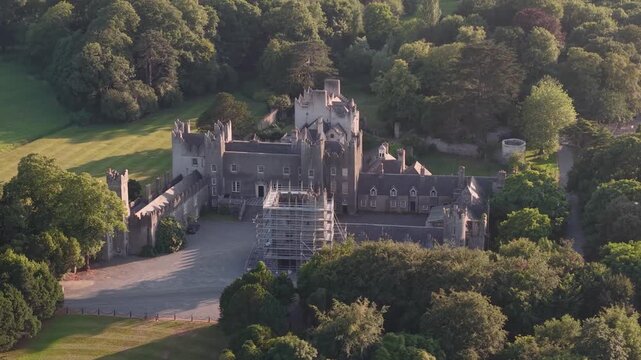 Golden sunset aerial close up over historic Howth Castle and surrounding parkland, County Dublin