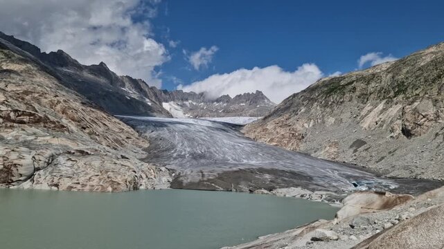 The rhone glacier receding in the swiss alps, creating a stunning glacial lake at its base