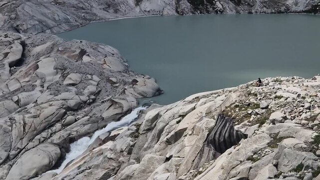 Glacial meltwater flowing into a turquoise alpine lake at the rhone glacier in the swiss alps