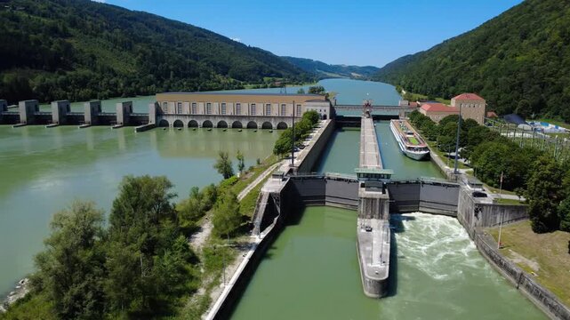 Aerial orbit of the lock and weir at the Jochenstein hydropower plant with rushing water