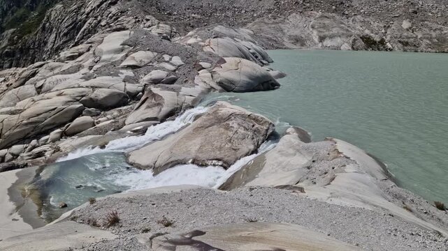 Glacial meltwater flowing from the rhone glacier forming a new lake in the swiss alps