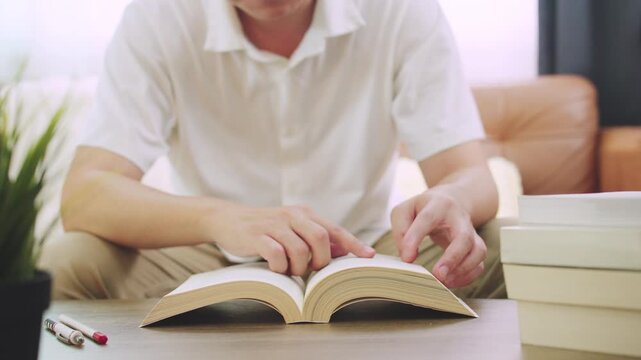Young Man Flipping Book Pages for Education and Research Concept.