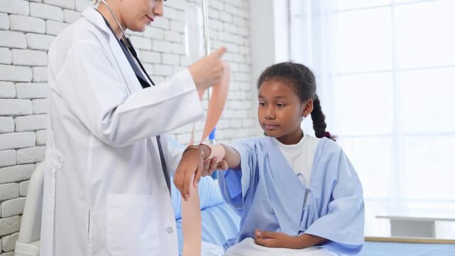 Caucasian female doctor wounding bandage around of little African American girl arm in hospital room