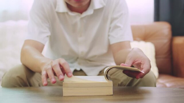 Closeup Young Man Reading and Flipping Book Pages for Education and Research Concept.