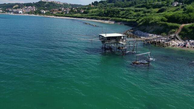 Zooming out from a fishing hut to reveal the coastline 4k drone