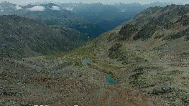 Scenic aerial landscape of Timmelsjoch in the Tyrol Alps featuring mountain peaks hidden in clouds on the Austria Italy border inspiring adventure travel tourism and pristine wilderness