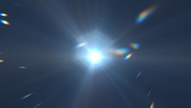 The image captures a bright sun shining intensely in a clear blue sky, with visible lens flare and sunbeams radiating outward, creating a dynamic and luminous outdoor scene.